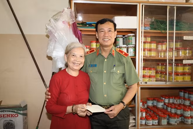 Deputy Minister Le Tan Toi presenting gift to a policy beneficiary family.