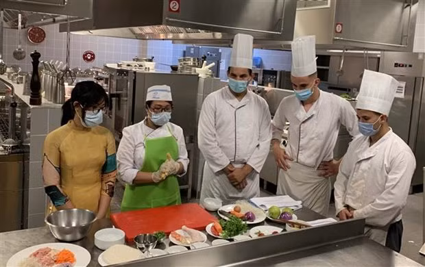 Students at the ESHRA learn to cook Vietnamese nem (fried spring rolls) (Photo: VNA)