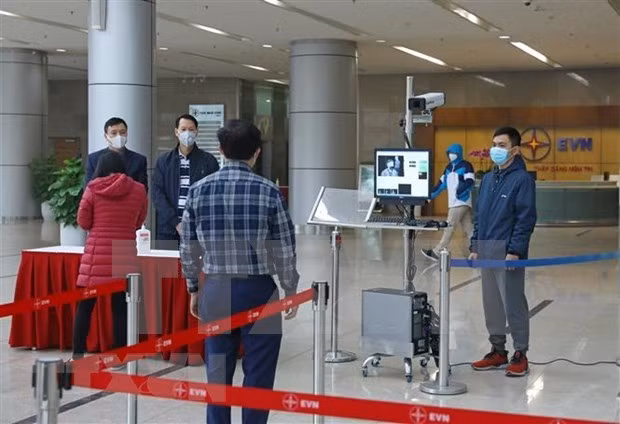 Temperature screening is conducted at an office building over fears of the nCoV outbreak. (Photo: VNA)