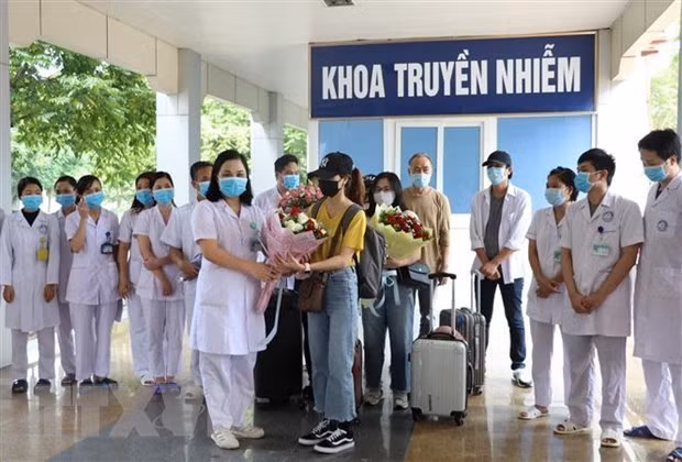 Leading officials of a hospital in Ninh Binh presents flowers to recovered COVID-19 patients (Source: VNA)