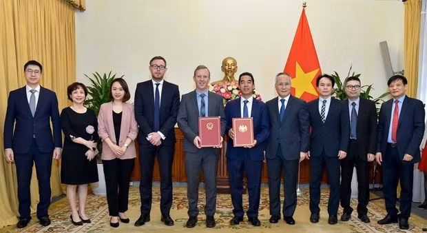 Representatives of Vietnam and the UK hand over notes confirming the date when the UKVFTA comes into force. (Photo: VNA)