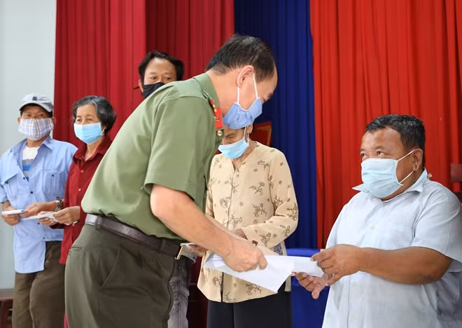 Senior Colonel Tran Kim Tham, Deputy Director of the Department for Information and Communications, Deputy Editor-in-Chief of the CAND Newspaper presenting gift to local needy households. Senior Colonel Tran Kim Tham, Deputy Director of the Department for Information and Communications, Deputy Editor-in-Chief of the CAND Newspaper presenting gift to local needy households.
