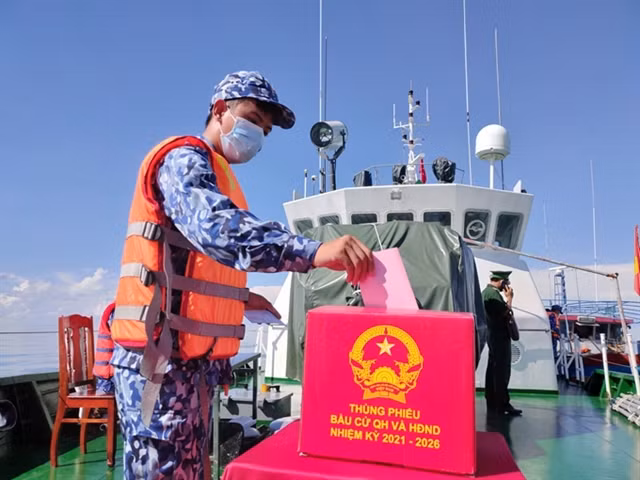 A coast guard soldier on duty at sea casts his ballot on a coast guard ship.