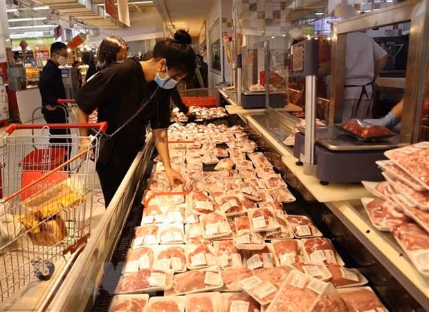 A consumer selects pork products at a supermarket (Photo: VNA) A consumer selects pork products at a supermarket (Photo: VNA)