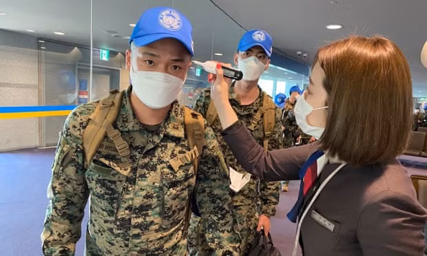 South Korean peacekeeping troops are checked for fever before boarding a flight. Photograph: South Korean Defense Ministry Handout/EPA South Korean peacekeeping troops are checked for fever before boarding a flight. Photograph: South Korean Defense Ministry Handout/EPA