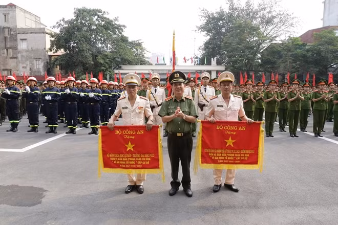 Deputy Minister Nguyen Van Son presents the Certificate of Merit from awarded by the Ministry of Public Security to the University of Fire Prevention and Fighting for its excellent achievements.