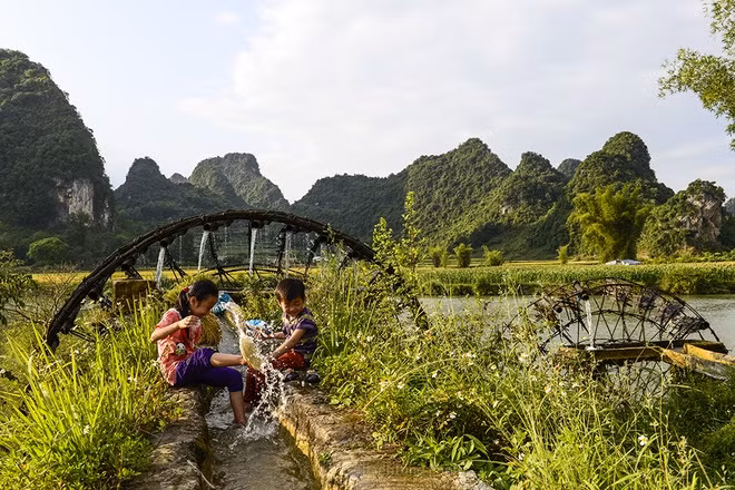 Children play by watermills.