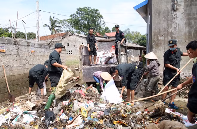 Hanoi's Mobile Police help locals clean up roads after prolonged flooding