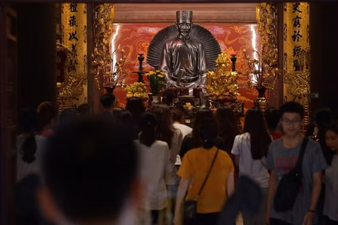 Students and their parents pray at the altar of Confucius inside the temple. In Vietnamese society, getting into university is the cornerstone for a stable future.