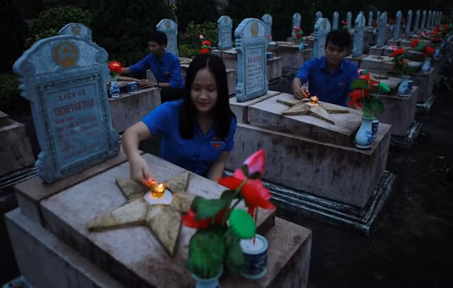 Students lit candles on graves of fallen soldiers at the Huong Dien martyrs' cemetery in the central province of Thua Thien - Hue on July 26. (Photo: VNA)