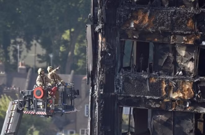 Firefighters use a hydraulic lift to inspect the Grenfell Tower block that was destroyed by fire, in north Kensington, West London, Britain June 16, 2017. REUTERS/Hannah McKay