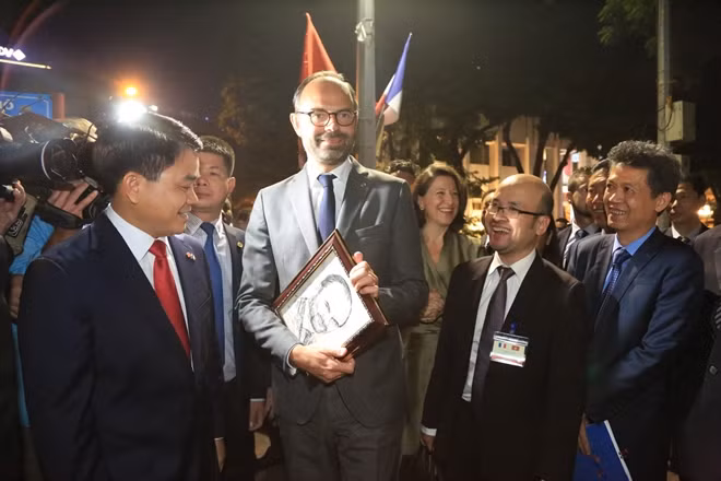 During the trip, the French Prime Minister received a beautiful portrait of him painted by a local street painter. Prime Minister Édouard Philippe appeared to be interested in the painting.