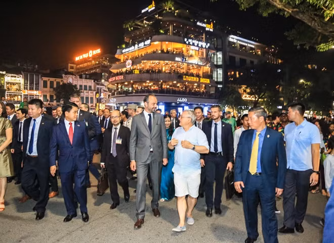 French Prime Minister speaks with a Frenchman near Dong Kinh Nghia Thuc Square.