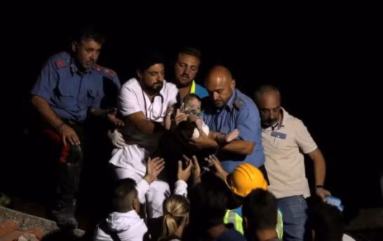 Italian Carabinieri police officer and a doctor carry a child after an earthquake hit the island of Ischia, off the coast of Naples, Italy August 22, 2017.