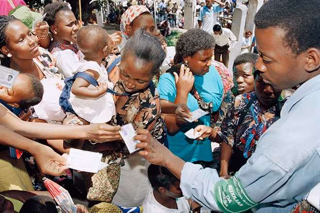 Voters in Mozambique flash their registration cards outside a polling station in a Maputo suburb. Photo: UN Photo/ Pernaca Sudhakaran