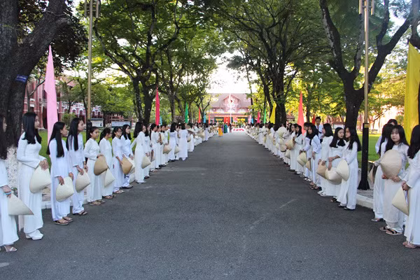 At Trung Vuong High School, girl-students in Ao dai (Vietnamese traditional long dress) were in long lines to enter the school through the gate.