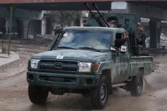 Rebel fighters ride on a pick-up truck mounted with a weapon as they drive in a rebel-held area of Aleppo, Syria December 7, 2016. REUTERS/Abdalrhman Ismail