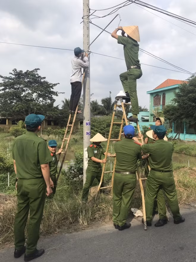Young police officers light up rural roads in Tien Giang province. Young police officers light up rural roads in Tien Giang province.