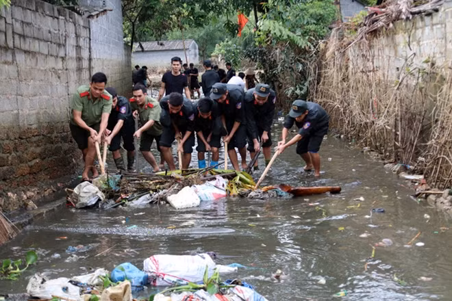 Hanoi's Mobile Police help locals clean up roads after prolonged flooding.