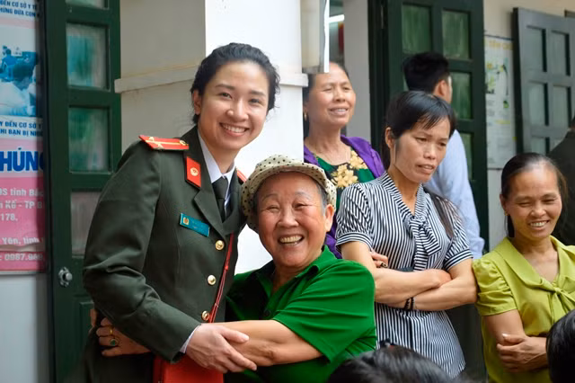 A local happily hugging a woman police officer during the drive. A local happily hugging a woman police officer during the drive.