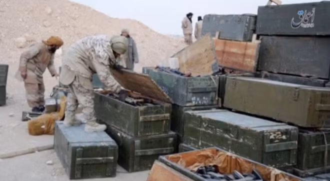 Islamic State fighters search weapon boxes in a Russian base in what is said to be Palmyra, Syria in this still image taken from video uploaded to social media on December 13, 2016. Amaq News Agency/Handout via Reuters TV