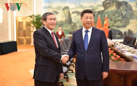 Politburo member and standing member of the Party Central Committee Secretariat Dinh The Huynh (L) and Party General Secretary and President of China Xi Jinping.