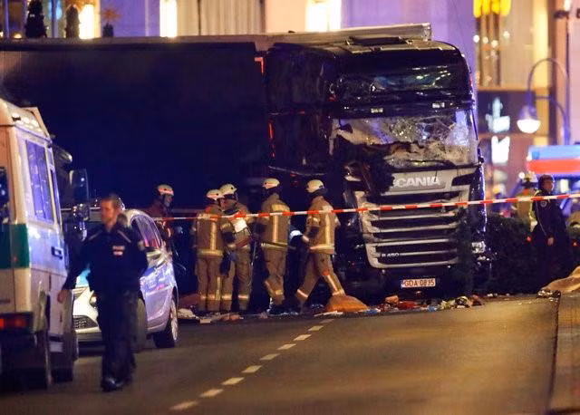 Police and emergency workers stand next to a crashed truck at the site of an accident at a Christmas market on Breitscheidplatz square near the fashionable Kurfuerstendamm avenue in the west of Berlin, Germany, December 19, 2016. REUTERS/Fabrizio Bensch