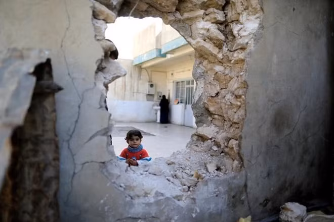 A girl stands in front of a hole used by Islamic state's fighters to move from house to house as a battle continues in western Mosul, Iraq March 10, 2017. REUTERS/Zohra Bensemra