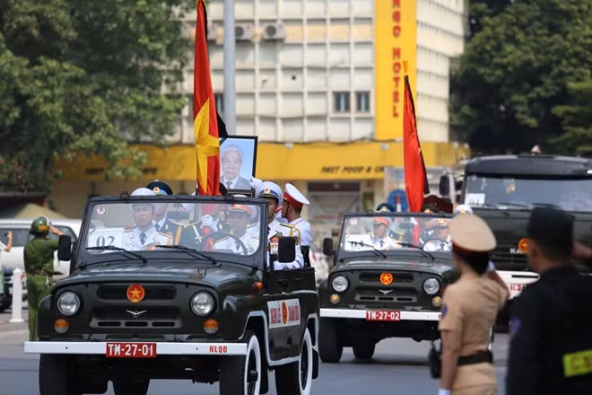 On-duty police officers solemnly salute to bid farewell to the late former Party chief.