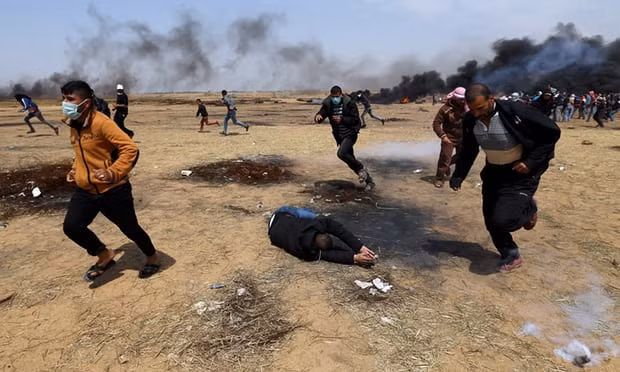 A wounded Palestinian during clashes with Israeli troops along the Gaza border. Photograph: Ibraheem Abu Mustafa/Reuters
