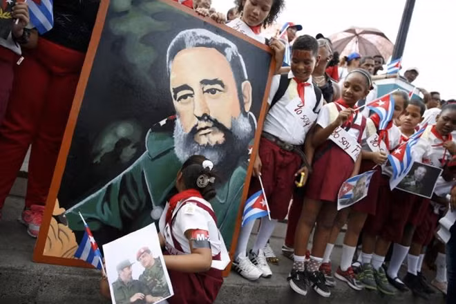 A student kisses a portrait of Cuba's late President Fidel Castro as the caravan carrying Castro's ashes arrives in Santiago de Cuba, Cuba, December 3, 2016. Photo: REUTERS/Carlos Garcia Rawlins