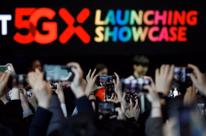 People take photographs during a launching ceremony for SK Telecom's 5G service, in Seoul, South Korea, April 3, 2019. REUTERS/Kim Hong-Ji