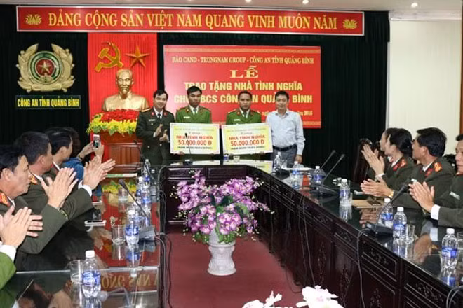 Representatives of CAND Newspaper working team and Trung Nam Group handing money to two policemen of Quang Binh Provincial Police.