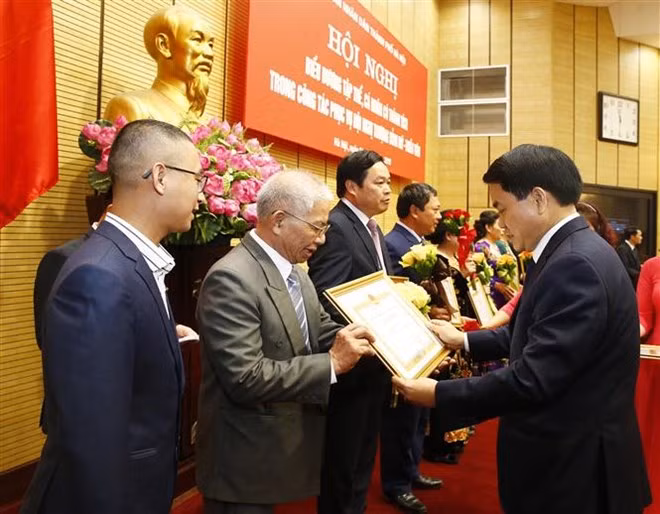 Chairman of the Hanoi People's Committee Nguyen Duc Chung (R) presents merit certificates to collectives and individuals with outstanding performances in serving the DPRK-USA Hanoi Summit Vietnam (Photo: VNA)
