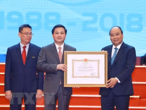 Prime Minister Nguyen Xuan Phuc (R) presents the government's first-class Labour Order to VietinBank at the ceremony marking its 30th founding anniversary