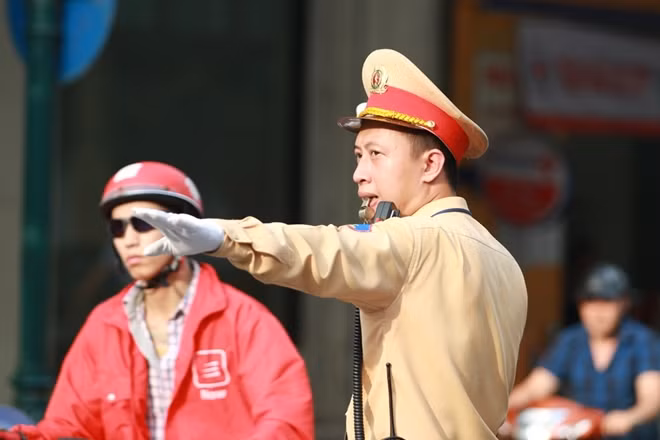 Senior Lieutenant Nguyen Xuan Truong, a police officer of Team 1 under the Hanoi Municipal Traffic Police Division is guiding the traffic at the Trang Tien – Hang Bai intersection.