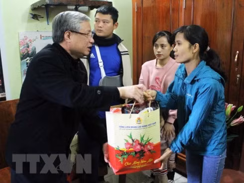 Politburo member and permanent member of the Party Central Committee's Secretariat Tran Quoc Vuong (L) presents gift to a worker in Bac Giang (Source: VNA)