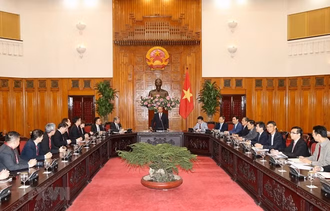 PM Nguyen Xuan Phuc (standing) at the reception for a delegation of 36 Singaporean businesses on July 15 (Photo: VNA)