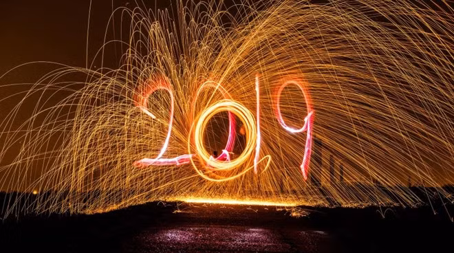 A man draws 2019 with a torch as a man behind him spins with a slingshot with burning steel wool. The flying sparks contrast against the night sky on Dec. 27 in Berlin, Germany.