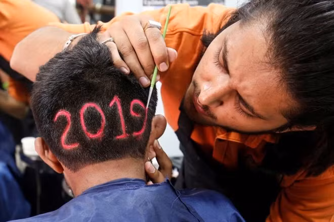 A man applies color to a haircut with the number "2019", depicted to welcome the new year at a barbershop in Ahmedabad, India, on Dec. 30.