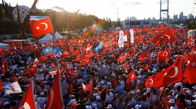 People wave Turkey's national flags as they attend a ceremony marking the first anniversary of the attempted coup at the Bosphorus Bridge in Istanbul, Turkey July 15, 2017. © Osman Orsal / Reuters
