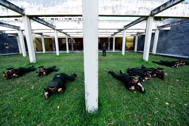 In pistol shooting, students must practice with various assumed scenarios. This photo features part of combat skills, using up terrains and objects to chase and arrest a target.