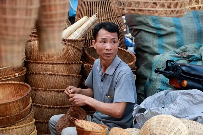 A seller rearranging his goods while waiting for visitors