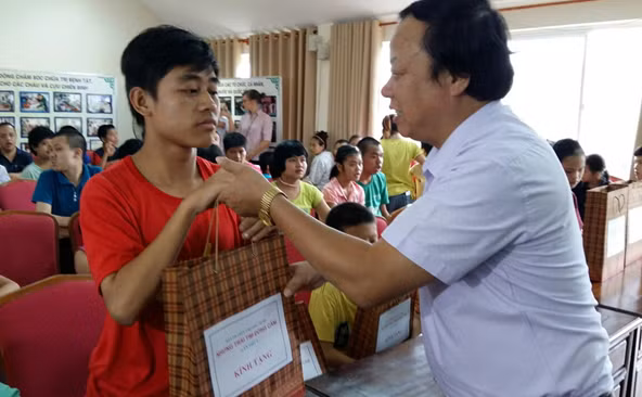Representative of the program presenting gift to children with difficulties.