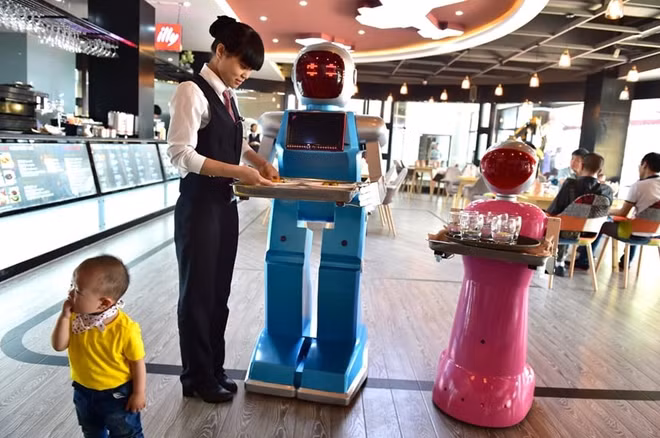Novelty value … a couple of AI waiters, Little Blue and Little Peach, at a robot-themed restaurant in Yiwu. Photograph: VCG via Getty Images