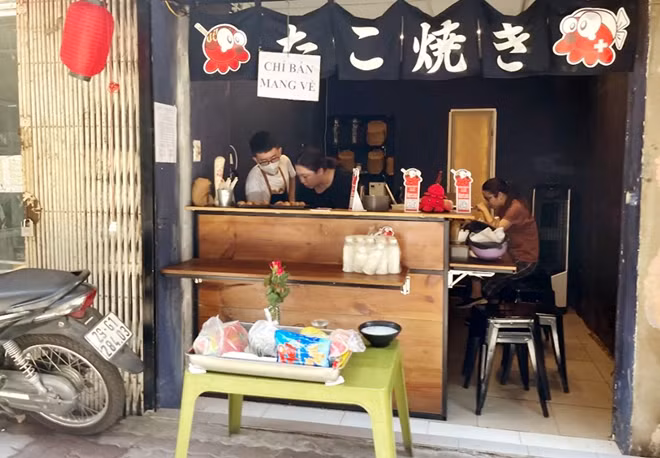 A restaurant shows the "Take away only" sign on its front door, but there is still a customer inside. According to a document issued by the Ha Noi’s Department of Justice, those who fail to temporarily suspend operation of their catering service facilities in epidemic-hit areas shall be subject to fines of VND 10,000,000 for individuals and 20,000,000 for organizations.