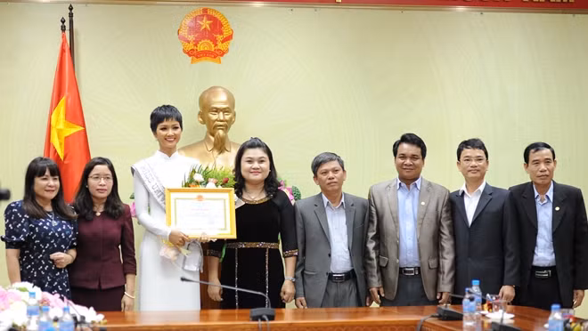 H'Hen Niê receiving the certificate of merit and gift from Dak Lak authorities.