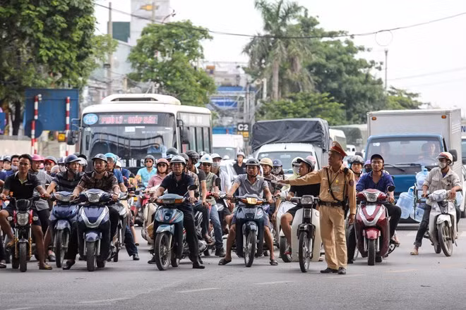 A police officer directs the traffic flow on a street in Hanoi. The capital city is making efforts to curb worsening traffic and pollution (Photo: VNA)