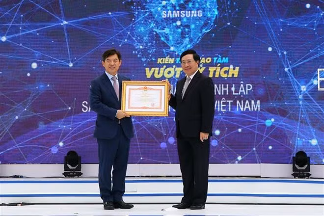 Deputy Prime Minister and Foreign Minister Pham Binh Minh (R) attends the 10th anniversary of Samsung Electronics Vietnam (Photo: VNA)