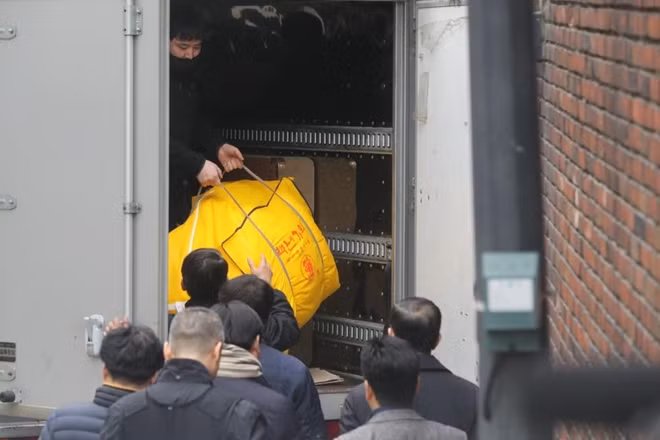 A huge bag is lifted into the back of the truck as disgraced Park is forced to leave the presidential palace